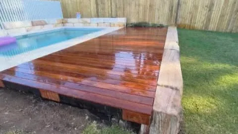 A stunning, modern timber pool deck surrounding the sparkling pool with seamless integration and a clean finish.